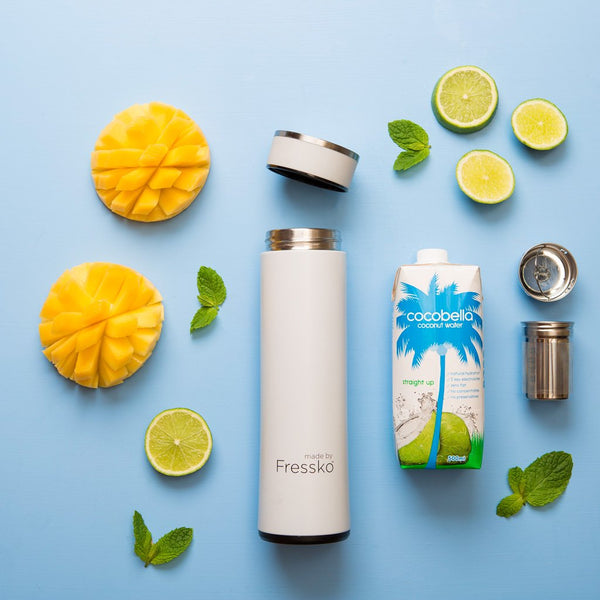 White Fressko flask surrounded by mango lime and coconut water
